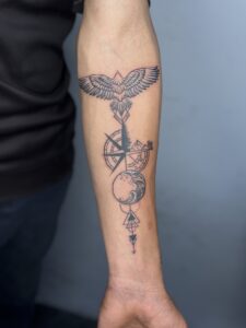 Black and grey tattoo of a flying bird and compass on forearm — 1920 Tattooz Hub, Ahmedabad