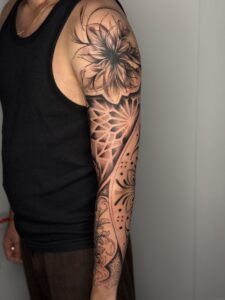 Black and grey tattoo of a large flower with geometric mandala patterns on arm sleeve — 1920 Tattooz Hub, Ahmedabad