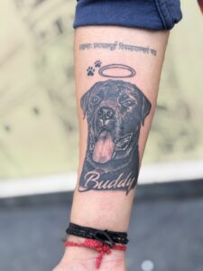 Black and grey memorial tattoo of a dog's portrait with a halo on forearm — 1920 Tattooz Hub, Ahmedabad
