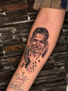 Black and grey memorial tattoo of a man's portrait with birds on forearm — 1920 Tattooz Hub, Ahmedabad