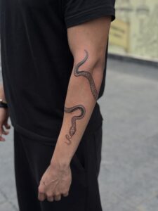 Black and grey tattoo of a snake winding down the inner arm — 1920 Tattooz Hub, Ahmedabad