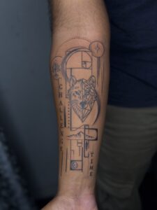Black and grey tattoo of a wolf head with geometric line art on forearm — 1920 Tattooz Hub, Ahmedabad