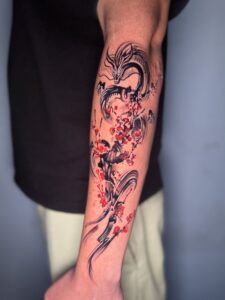 Colored tattoo of a dragon with cherry blossoms on forearm — 1920 Tattooz Hub, Ahmedabad