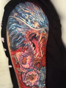 Colored tattoo of a dragon with peony flowers on shoulder — 1920 Tattooz Hub, Ahmedabad