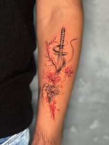 Colored tattoo of a katana sword with flowers on forearm — 1920 Tattooz Hub, Ahmedabad