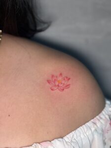 Colored tattoo of a small lotus flower on shoulder — 1920 Tattooz Hub, Ahmedabad