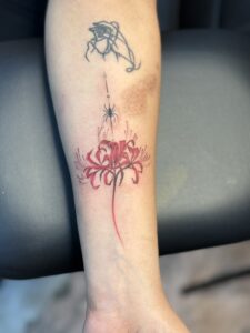 Colored tattoo of a red spider lily with a spider on forearm — 1920 Tattooz Hub, Ahmedabad