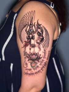 Colored tattoo of Shiva with a trishul and lotus on shoulder — 1920 Tattooz Hub, Ahmedabad