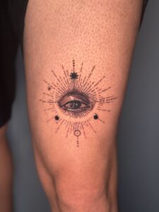 Fine line tattoo of an eye with a sunburst mandala on calf — 1920 Tattooz Hub, Ahmedabad