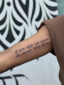 Fine line tattoo of a Sanskrit shlok on upper arm — 1920 Tattooz Hub, Ahmedabad