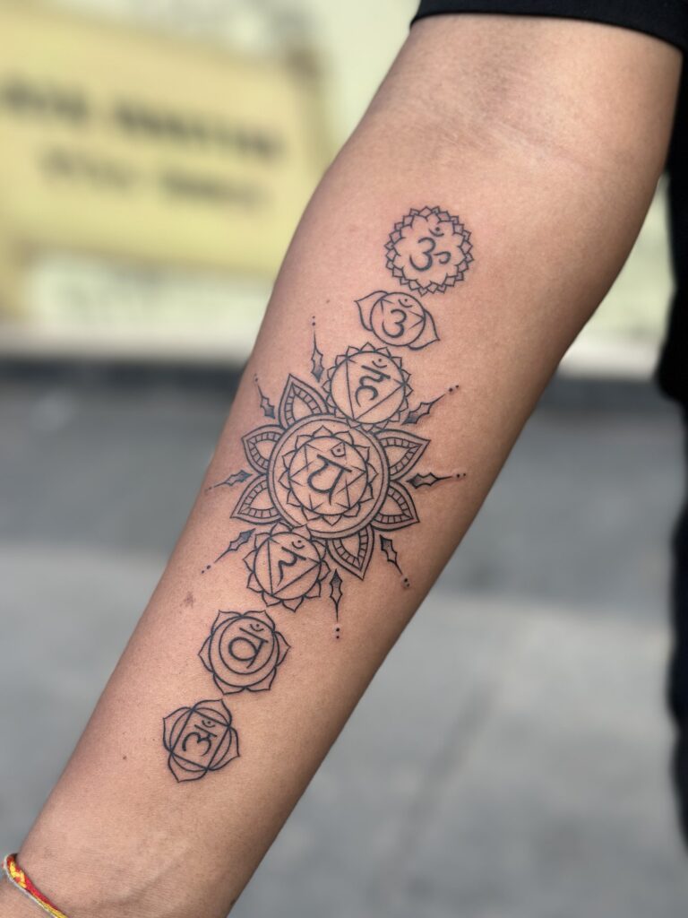 Fine line tattoo of the seven chakras on forearm — 1920 Tattooz Hub, Ahmedabad