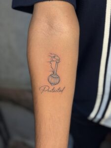 Minimalist tattoo of a mace with Protected script on forearm — 1920 Tattooz Hub, Ahmedabad