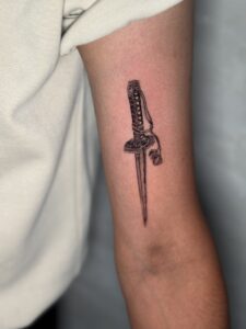 Minimalist tattoo of an ornate dagger on bicep — 1920 Tattooz Hub, Ahmedabad