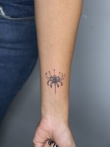 Minimalist tattoo of a spider lily flower on wrist — 1920 Tattooz Hub, Ahmedabad
