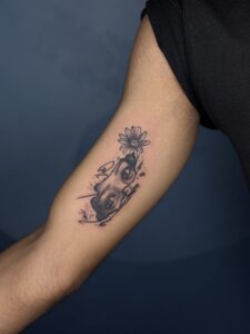 Realistic tattoo of a fragmented face with a daisy flower on forearm — 1920 Tattooz Hub, Ahmedabad
