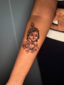 Realistic tattoo of baby Krishna on forearm — 1920 Tattooz Hub, Ahmedabad
