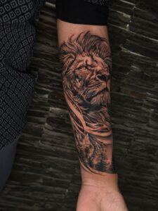 Realistic tattoo of a lion's face on forearm — 1920 Tattooz Hub, Ahmedabad