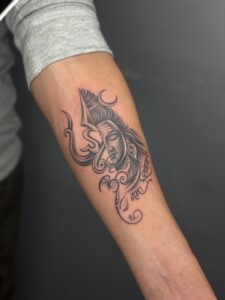 Realistic tattoo of Lord Shiva's face merging into a trishul on forearm — 1920 Tattooz Hub, Ahmedabad